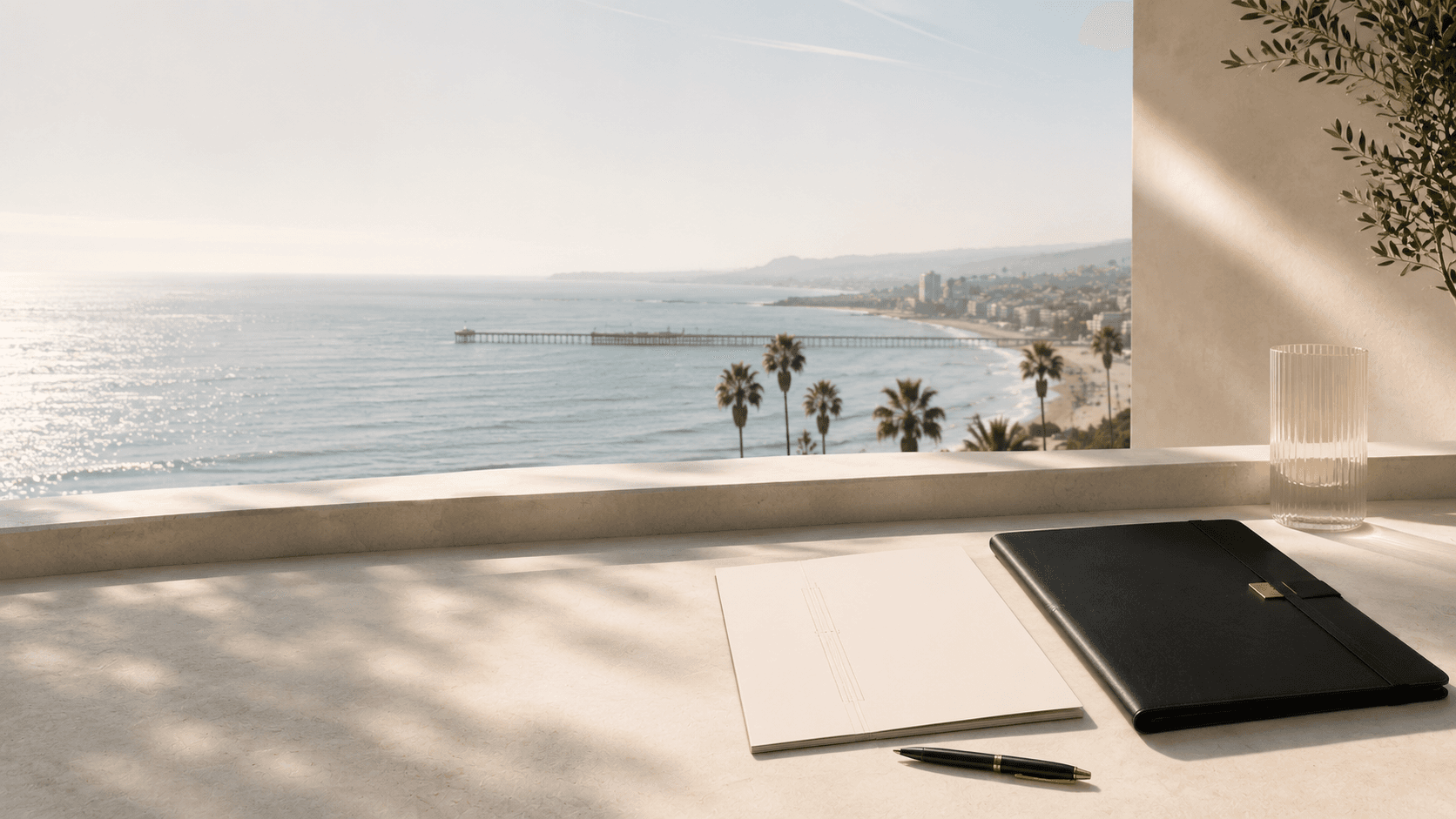 Ocean view terrace with a notebook, portfolio and pen overlooking the coast